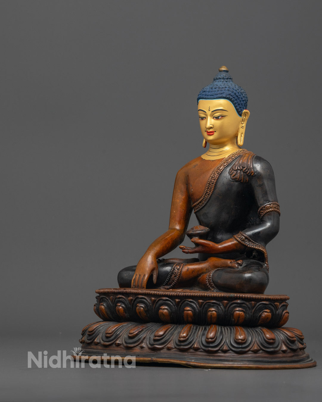 Side angle of handcrafted Tibetan Buddha with rich oxidized copper and bright finish

