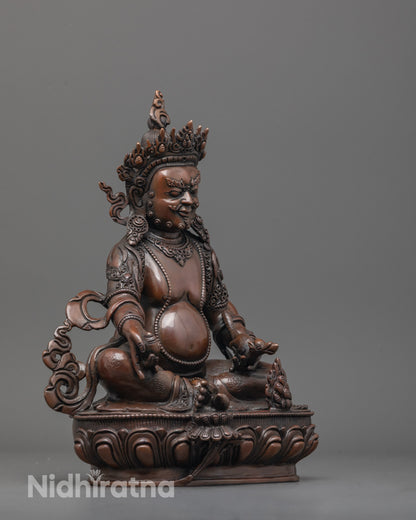 Side angle of oxidized Dzambhala statue holding mongoose and citron fruit in royal pose