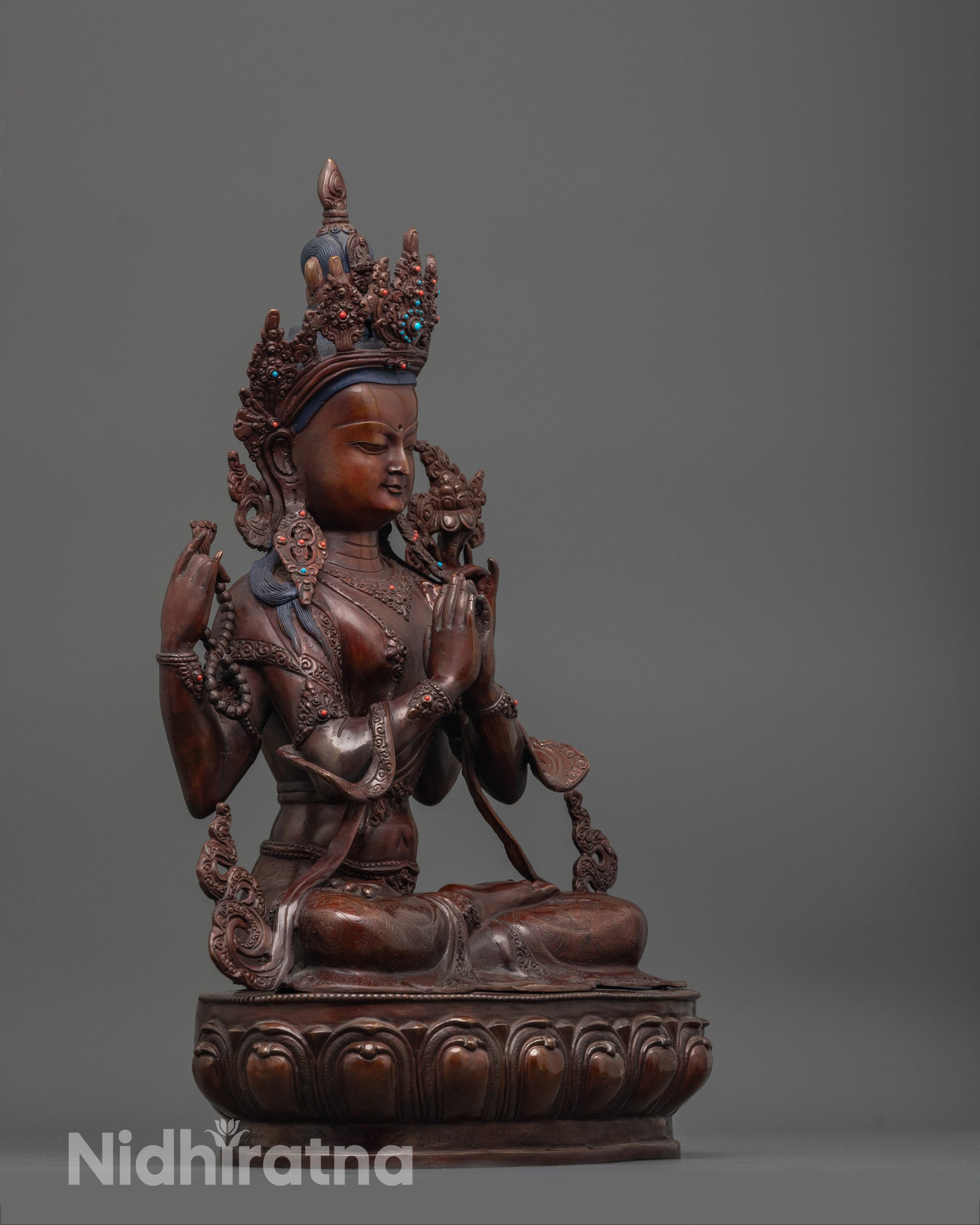 Side angle of oxidized copper Chenrezig Statue highlighting swirling robe and brownish hue