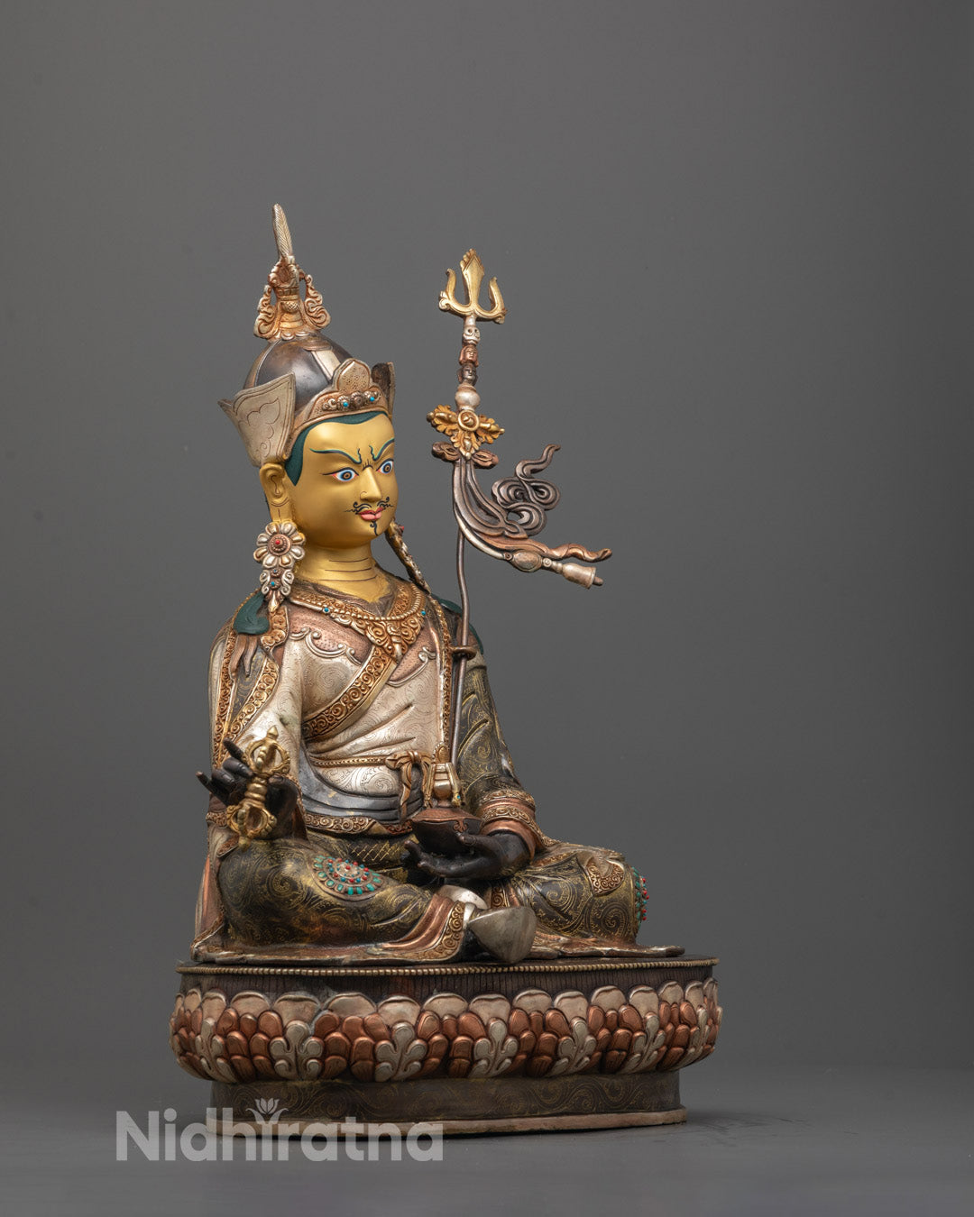 Side angle of oxidized copper Padmasambhava Statue with silver, gold, and copper-plated details