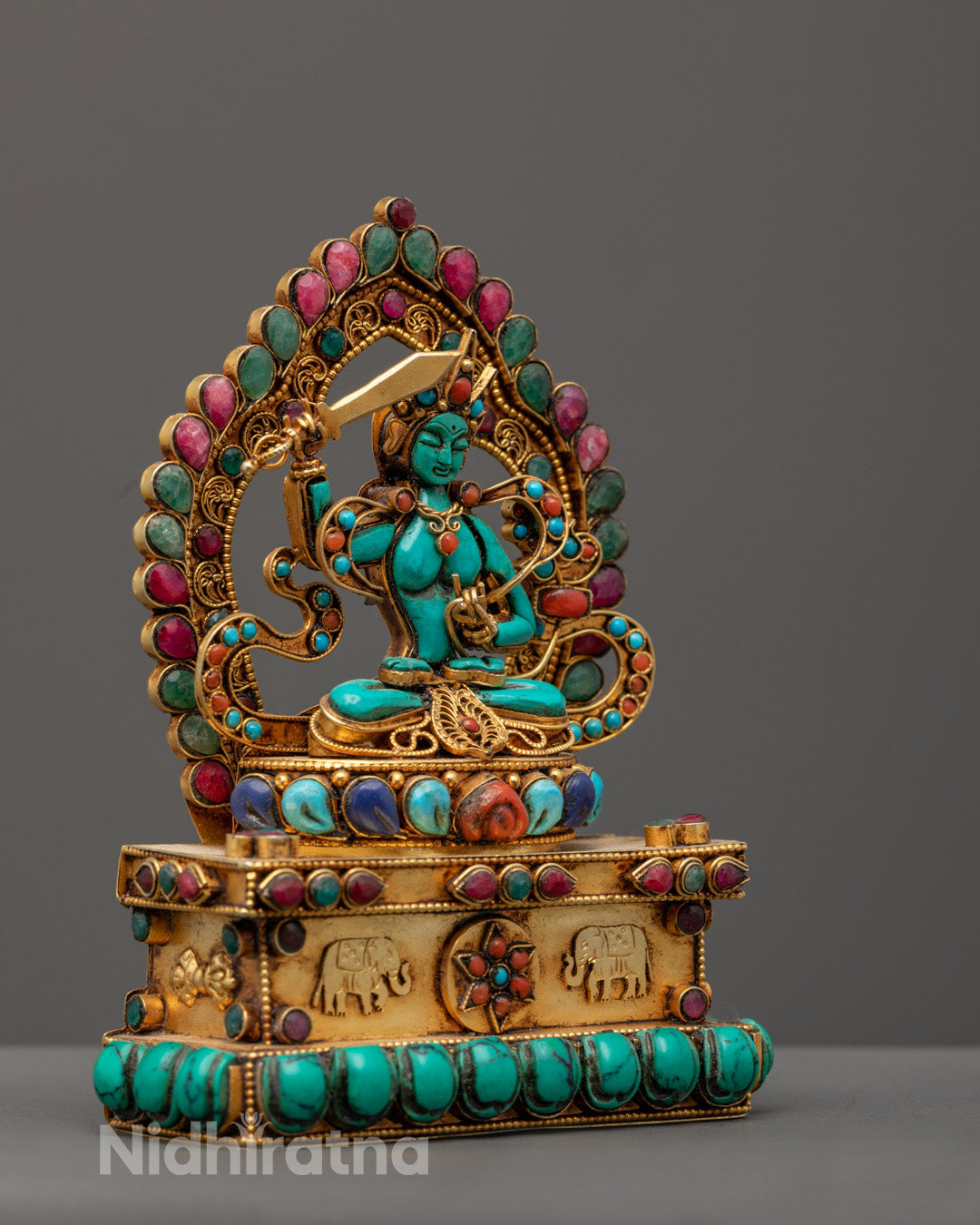 stone Manjushri statue revealing the intricate carving of the lotus base and robe patterns.