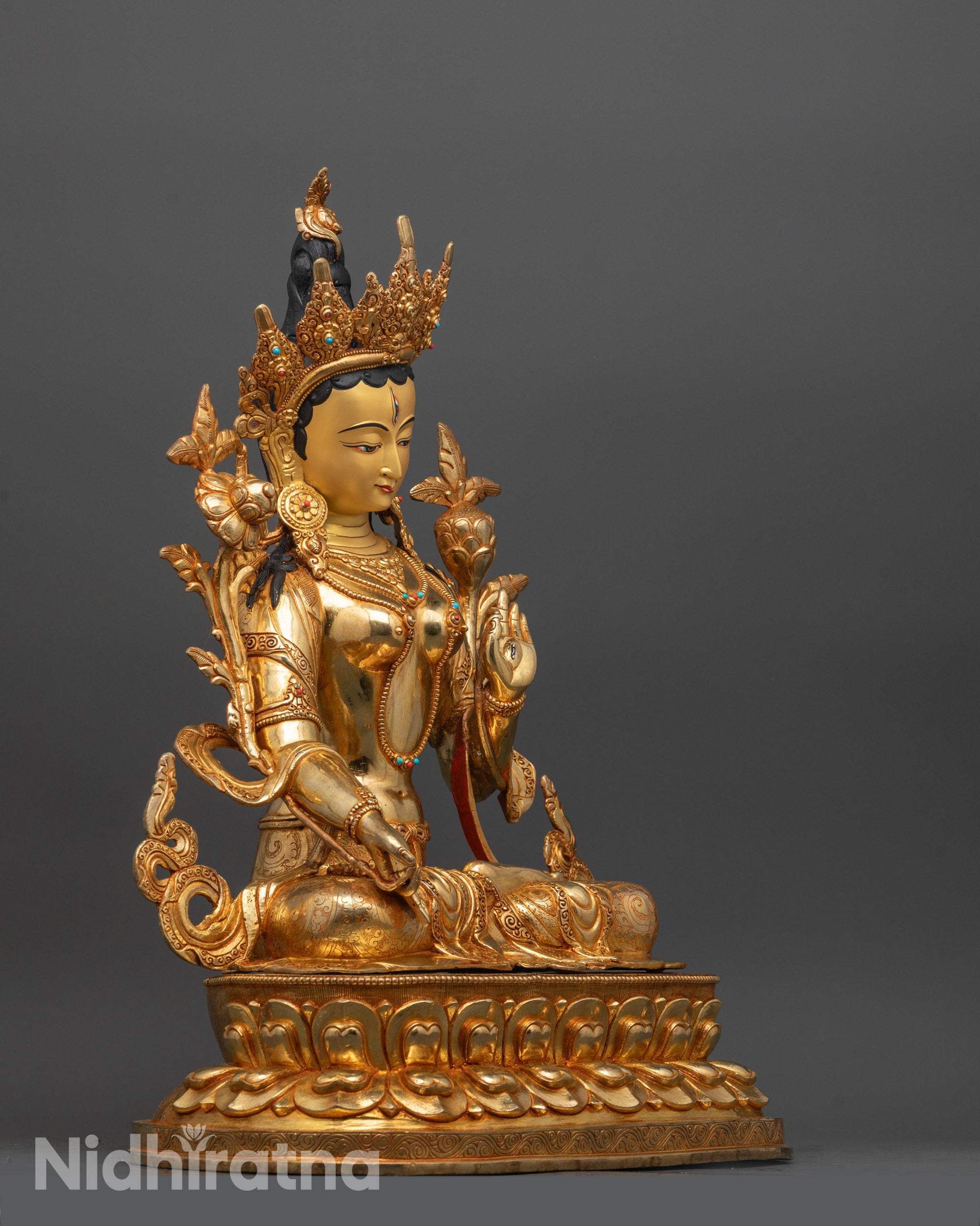 Side angle showing White Tara statue’s Varada mudra hand and intricate lotus seat carving