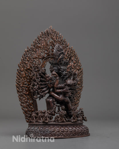 Side angle showing Yamantaka embracing consort and smaller deities at statue base