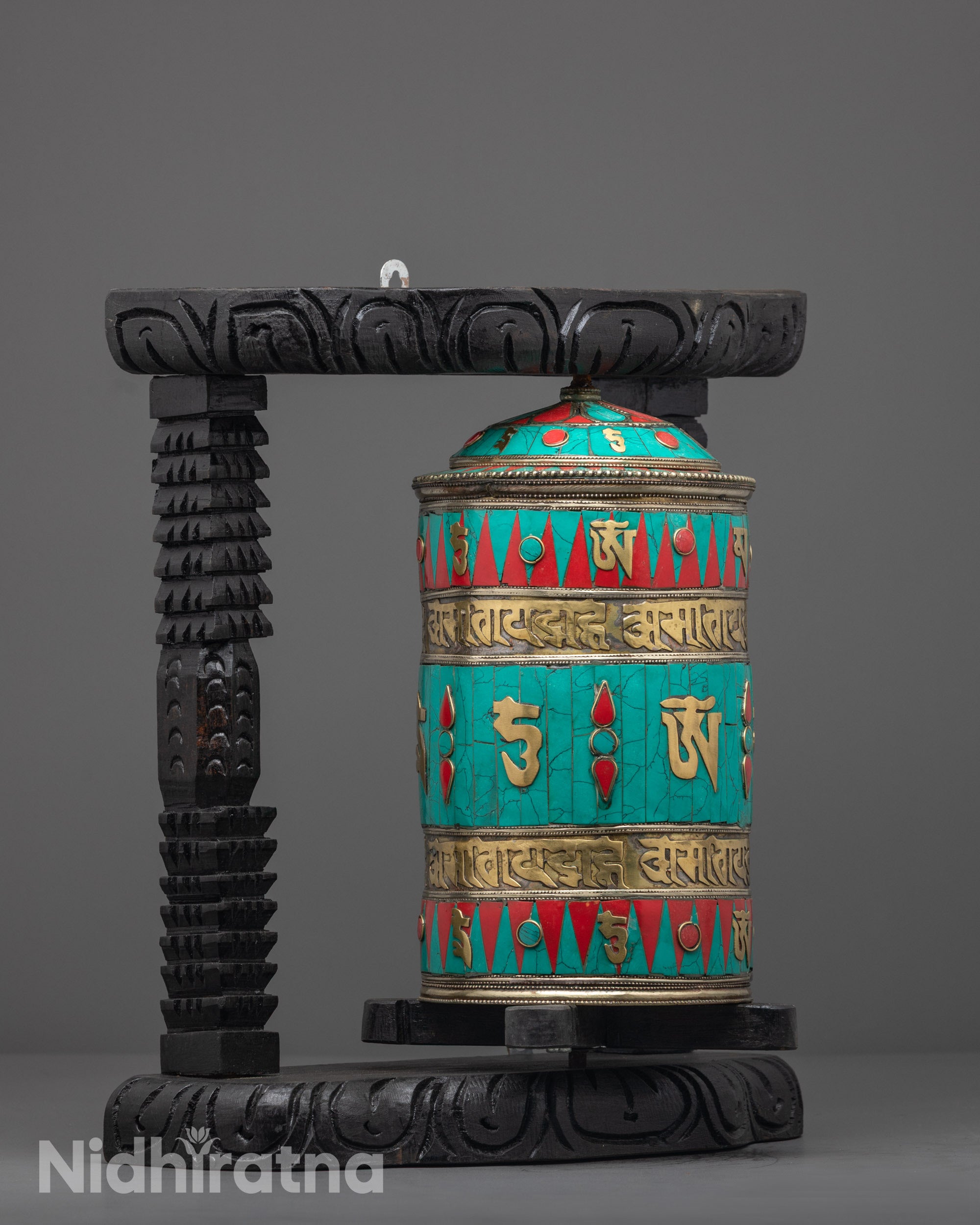 Side angle showing coral and turquoise inlays on copper Prayer Wheel frame