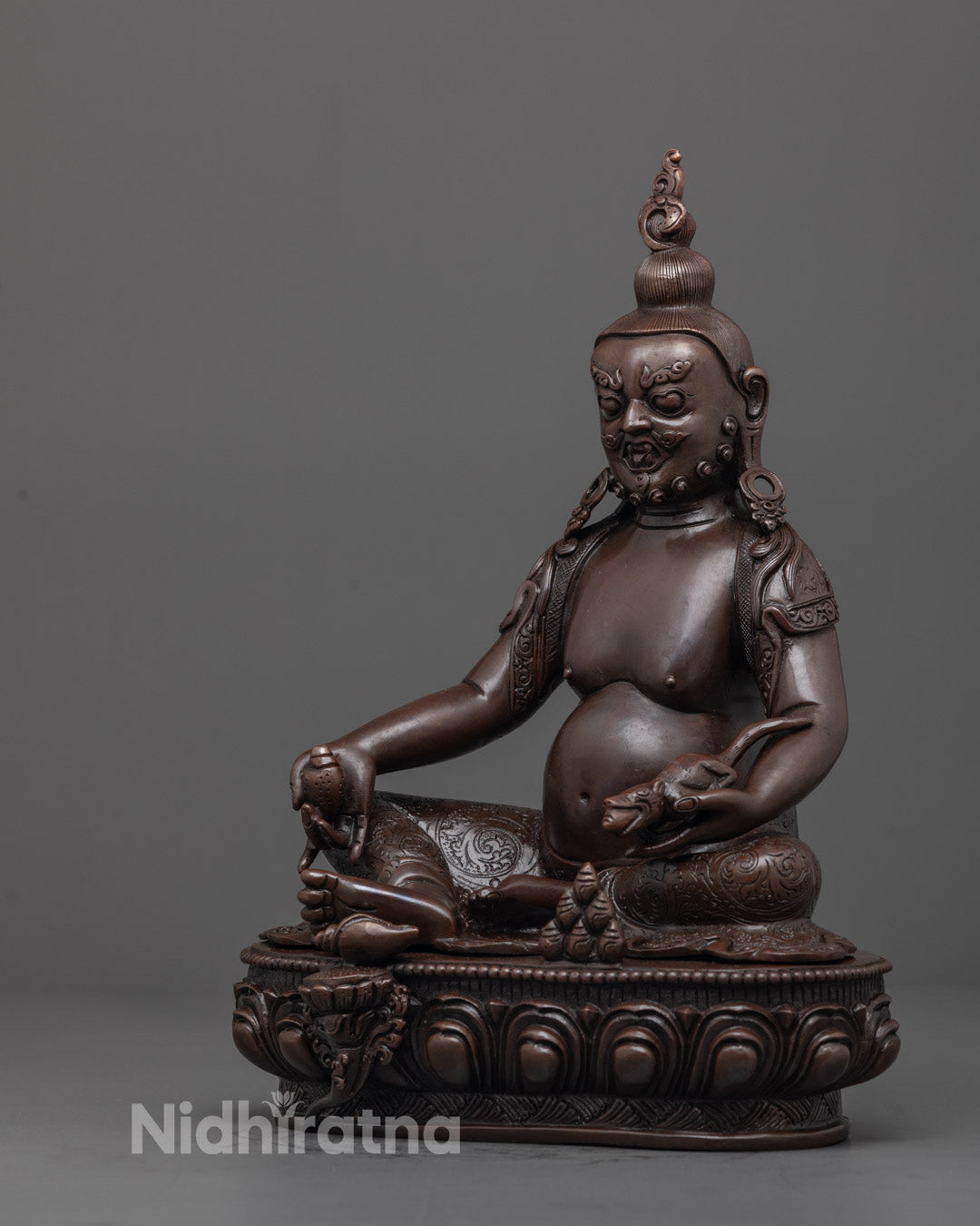Side angle showing detailed carving on floating robe and ornate crown of Jambhala statue