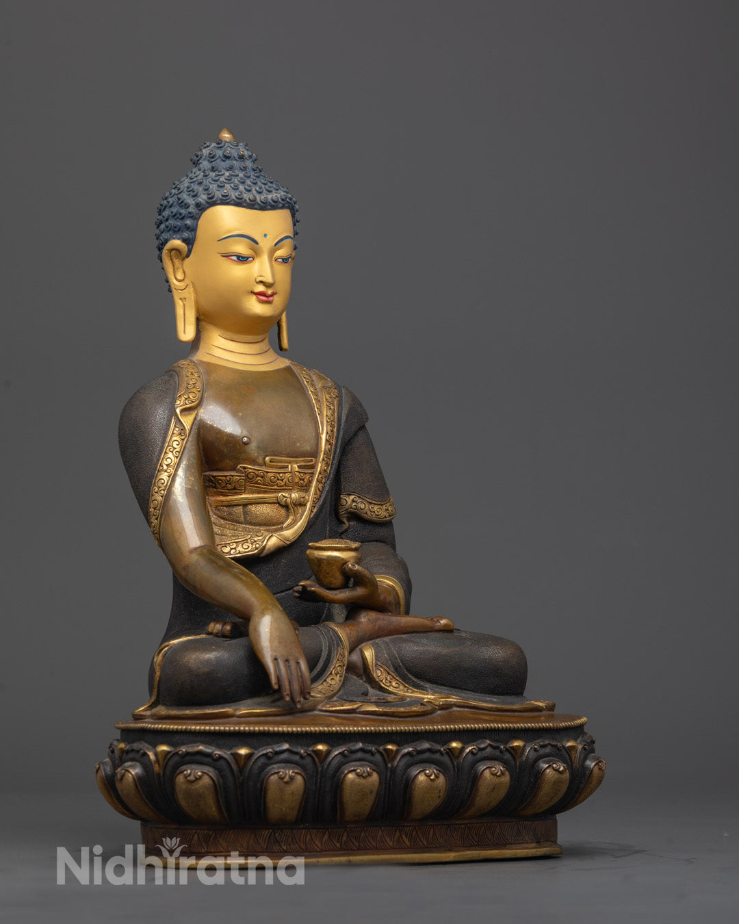 Side angle showing gold-edged robe and lotus throne on oxidized copper Buddha statue