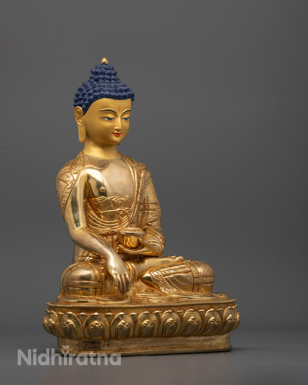 Side angle showing intricate body design and gold gilded surface of Buddha statue