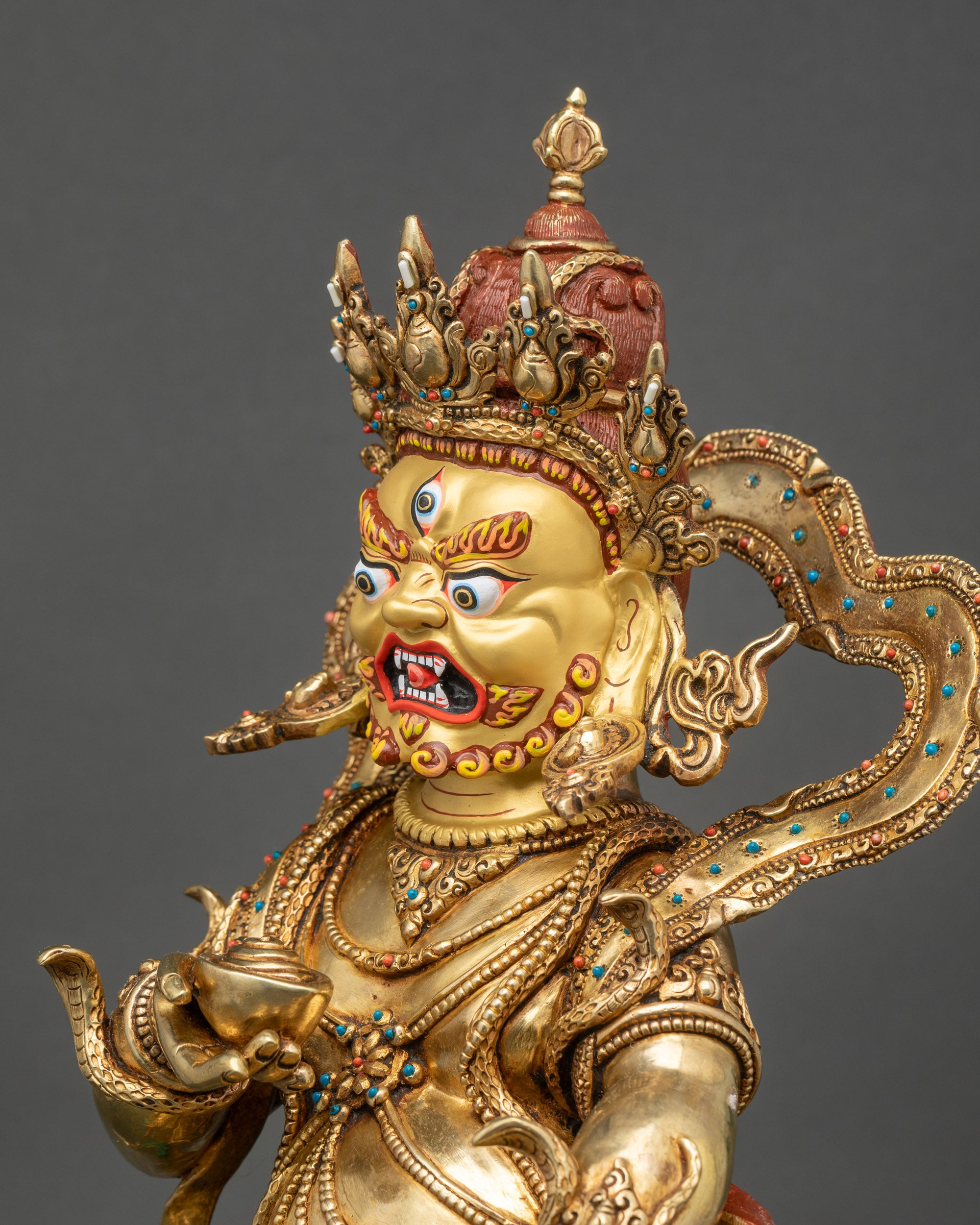 Side close-up of Black Dzambhala statue highlighting tiger skin garments and intricate patterns