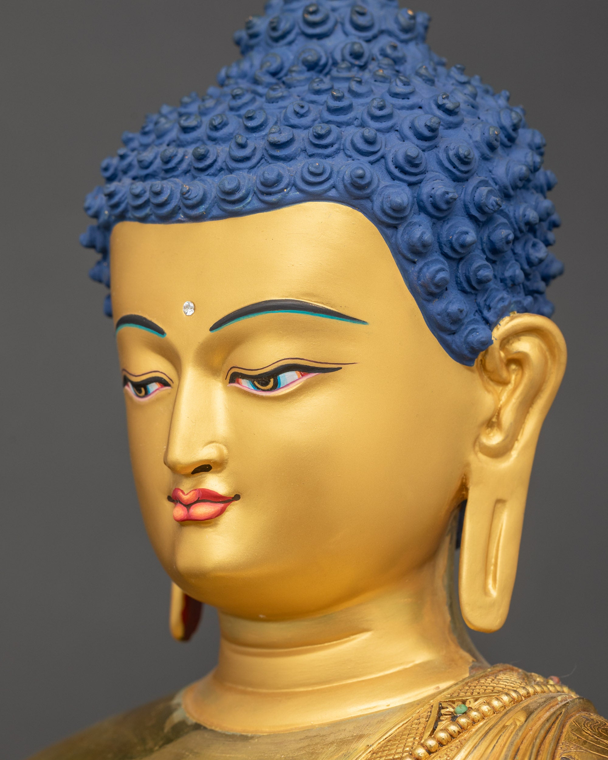 Side close-up of Buddha’s face with reflective gold-gilded features and calm expression