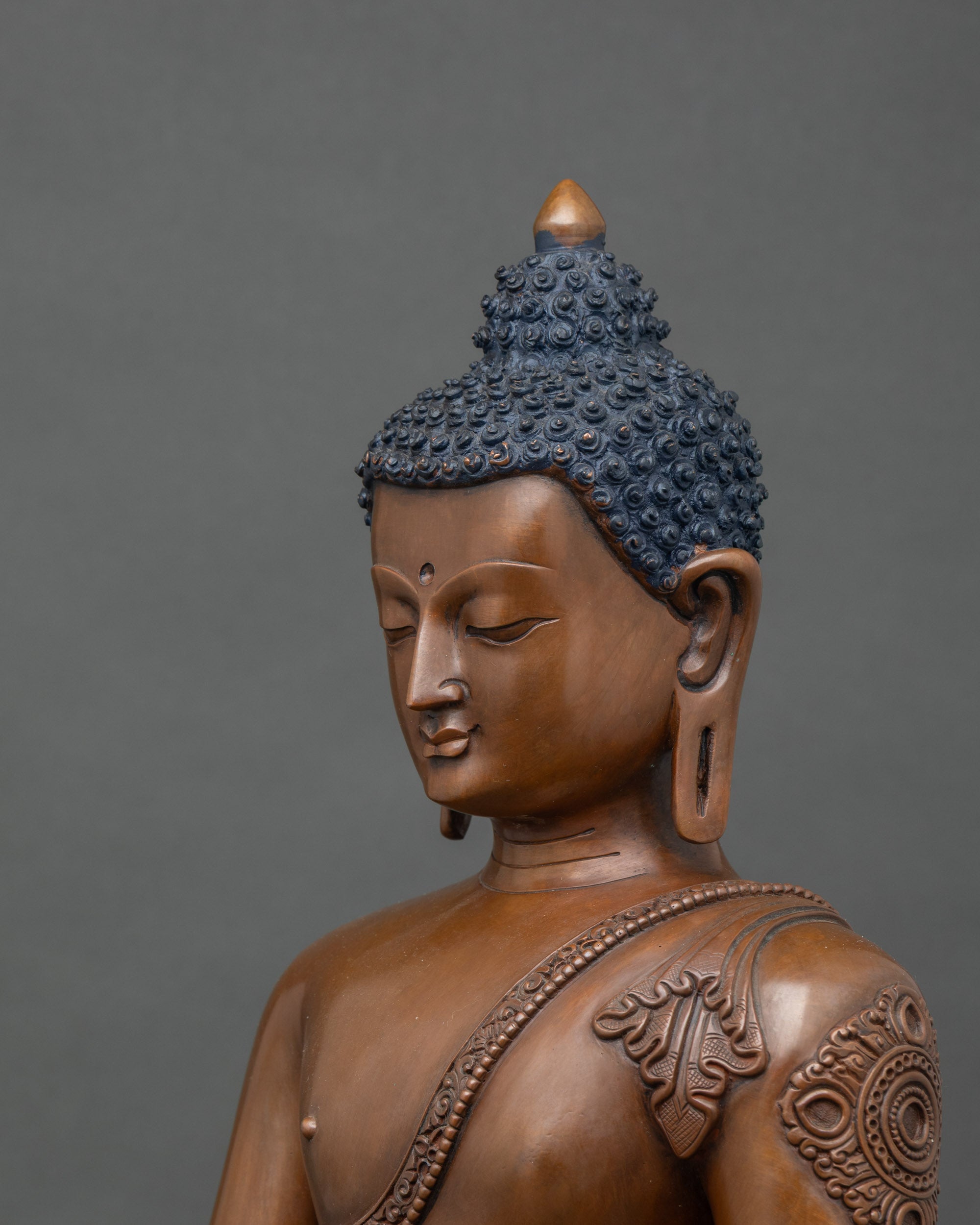 Side close-up of Gautama Buddha statue highlighting Bhumisparsha mudra and lotus throne