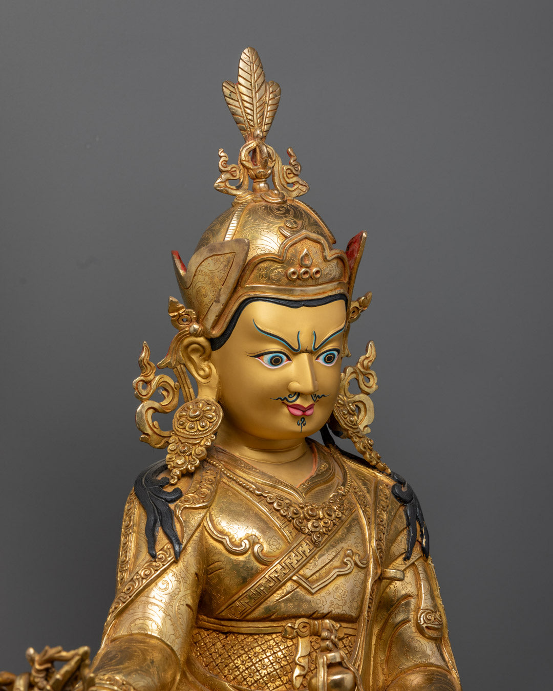 Guru Rinpoche Statue showing detailed craftsmanship, gold-gilded copper body, and vajra in hand.