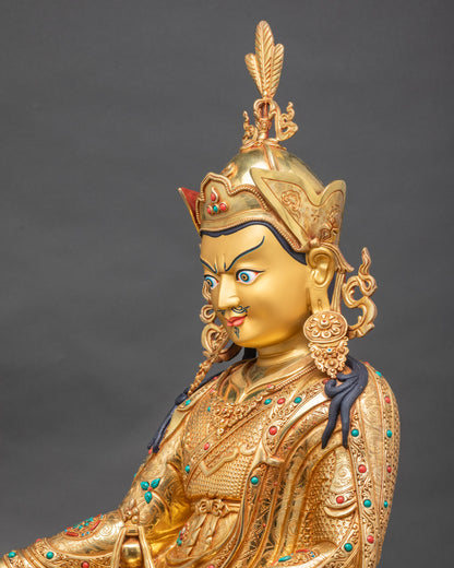 Side close-up of Guru Rinpoche statue highlighting skull cup and Dorje with trident