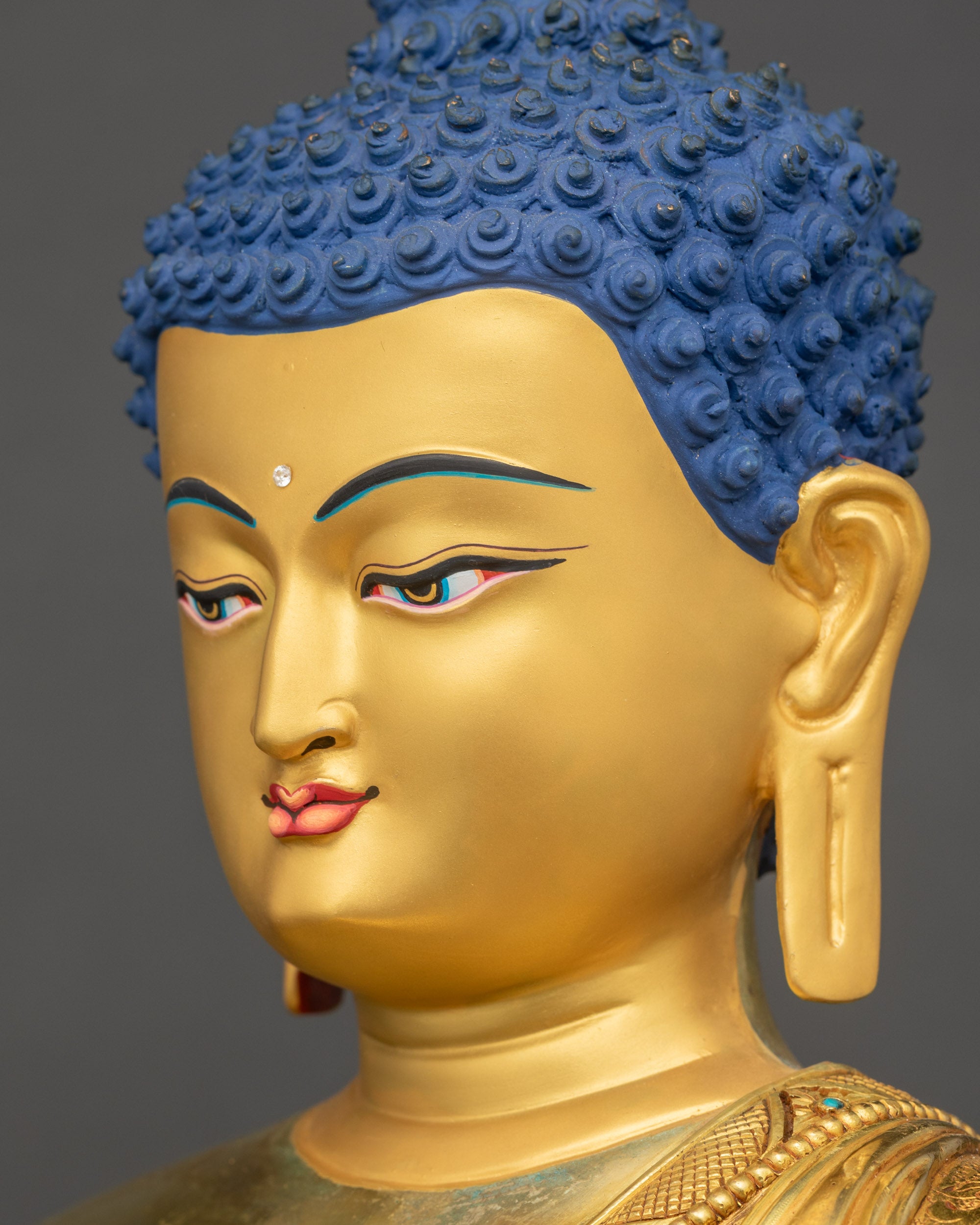 Side close-up of Buddha’s face with reflective gold-gilded features and peaceful gaze