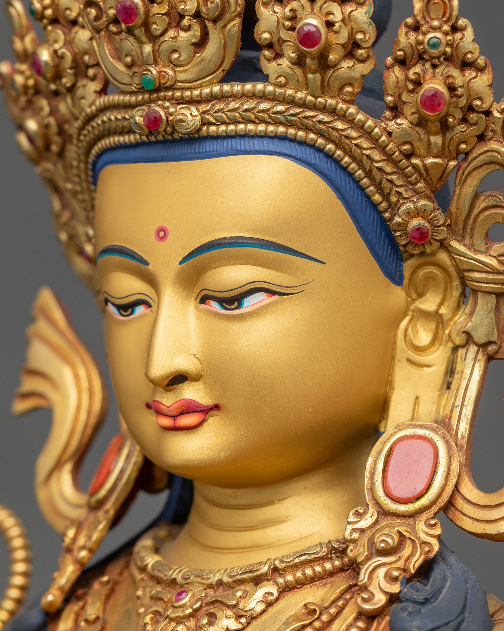 Side close-up of Shakyamuni Buddha face with intricate gold-gilded features
