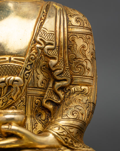 Side close-up of Shakyamuni Buddha statue, carved monastic garments and lotus pedestal