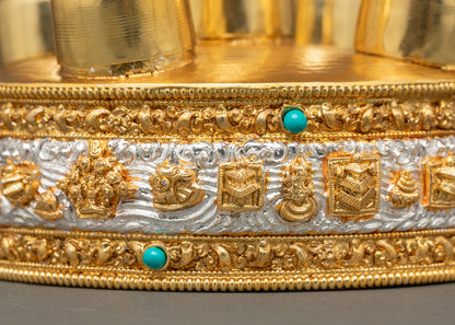 Side close-up of gold fire-gilded Torma spire with auspicious symbols on base