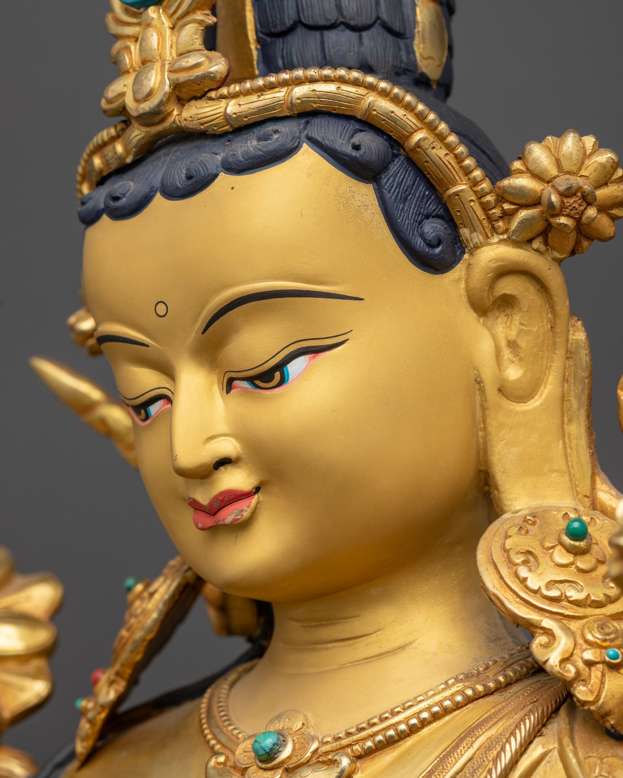 Side close up face Green Tara Statue displaying tranquil expression and intricate jewelry
