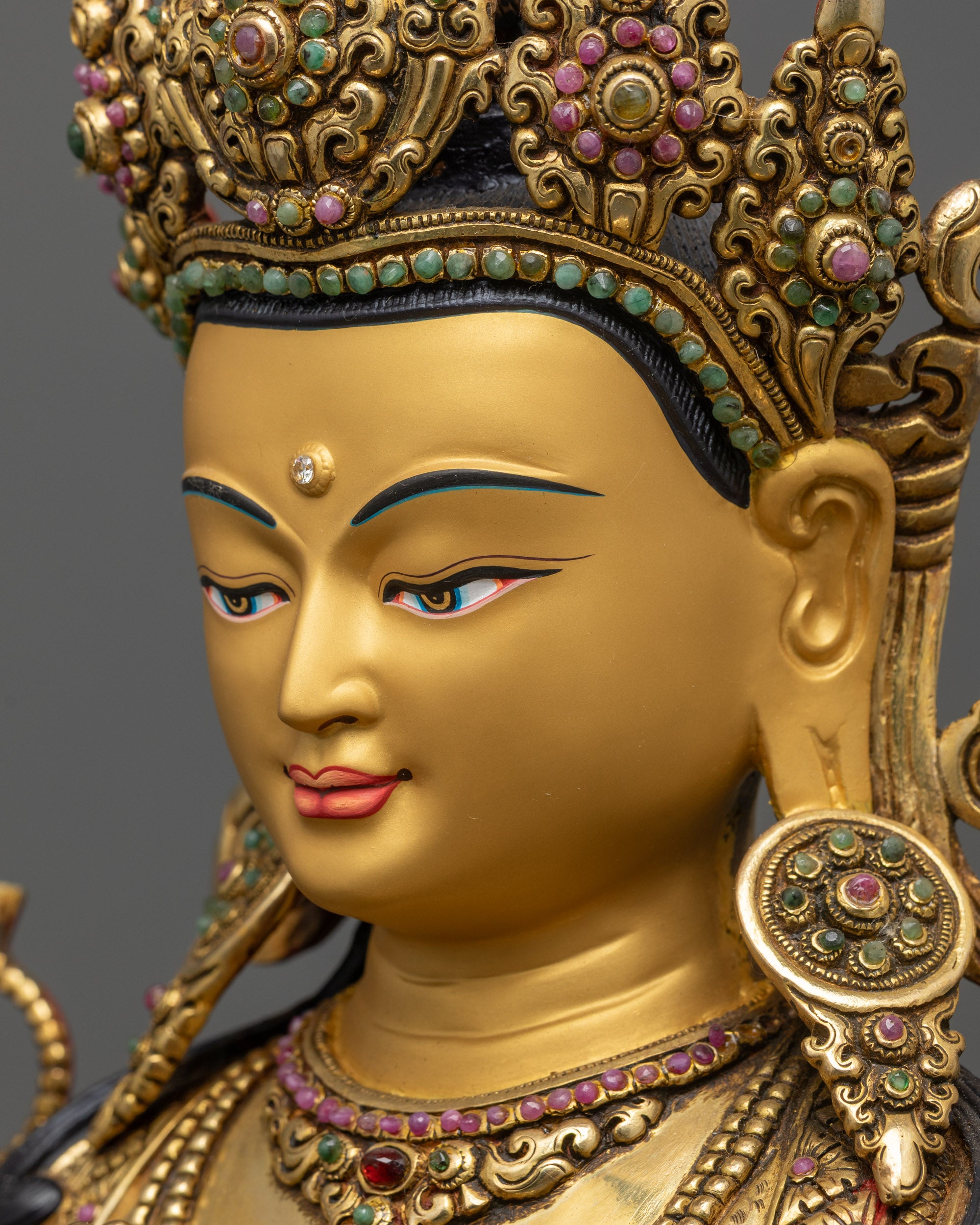 Side close up face of Chenrezig statue highlighting luminous halo and gold-gilded features
