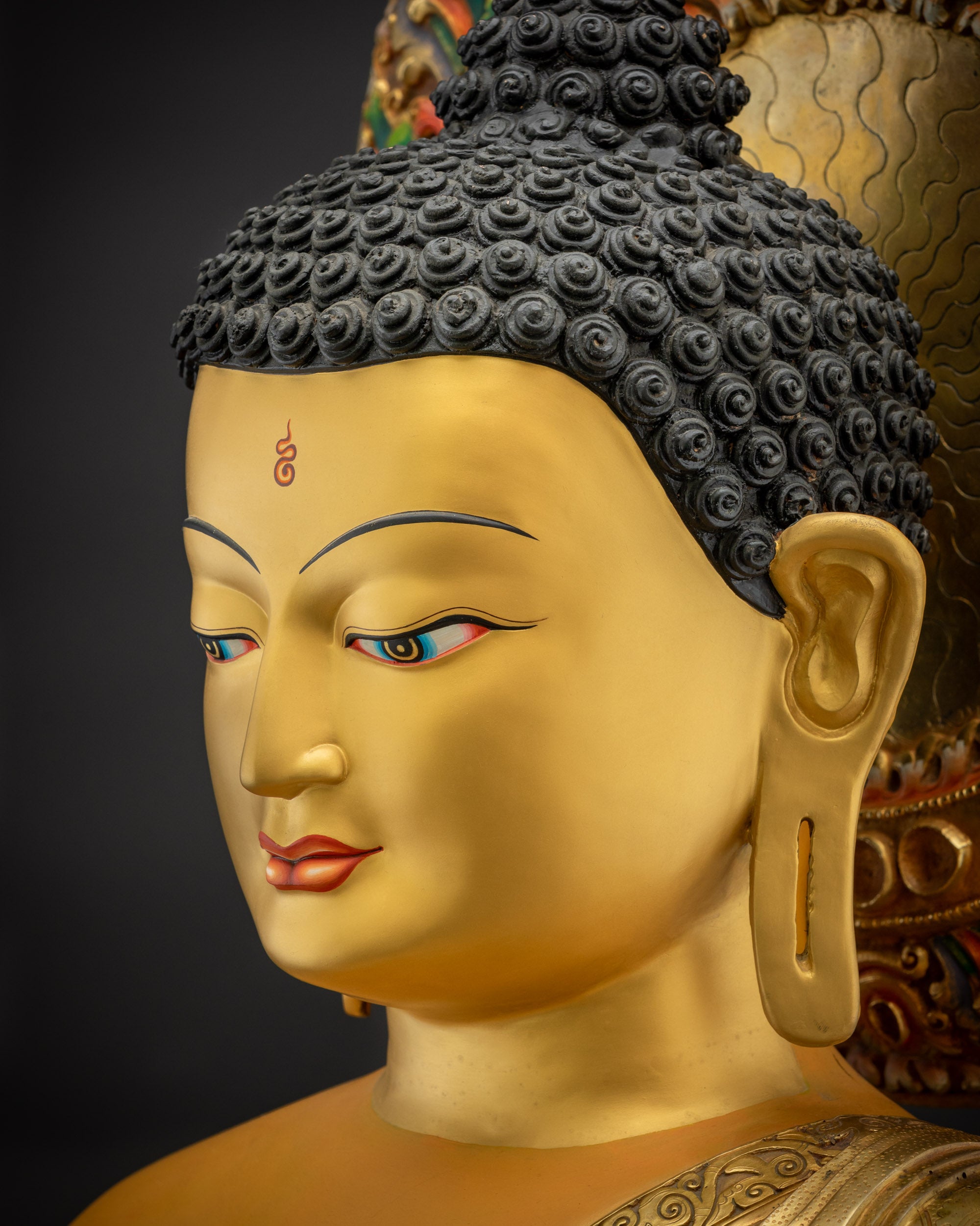 Side close up face of Shakyamuni Buddha Siddhartha Gautama Statue golden robe
