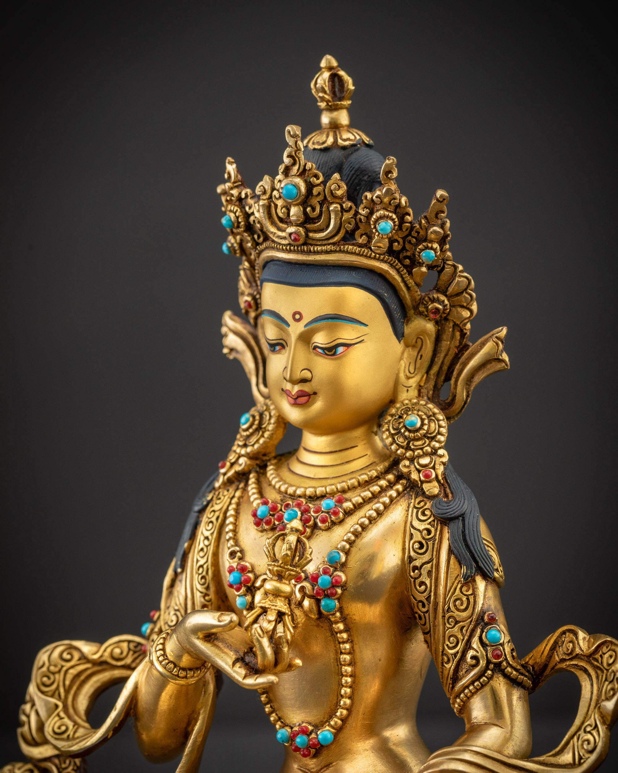 Side close up of Vajrasattva face highlighting calm expression and gold-gilded features

