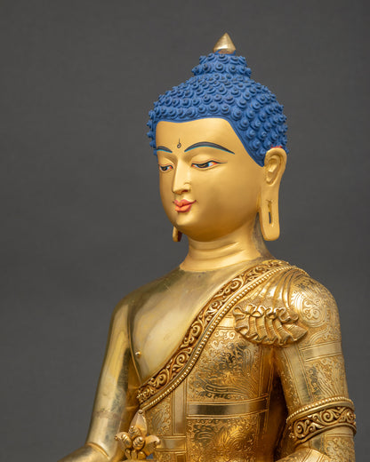 Side close up of gold Medicine Buddha statue highlighting robe patterns