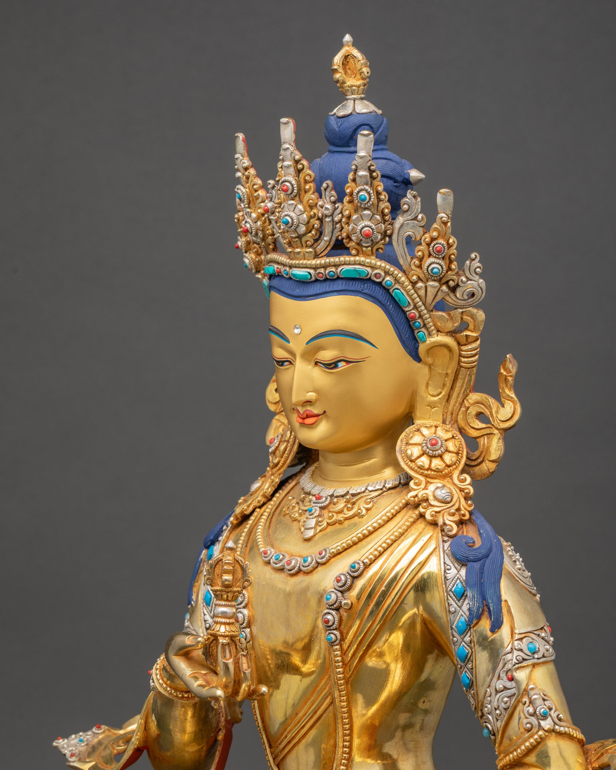 Side close up showing Vajrasattva holding ritual vajra and bell in meditation pose