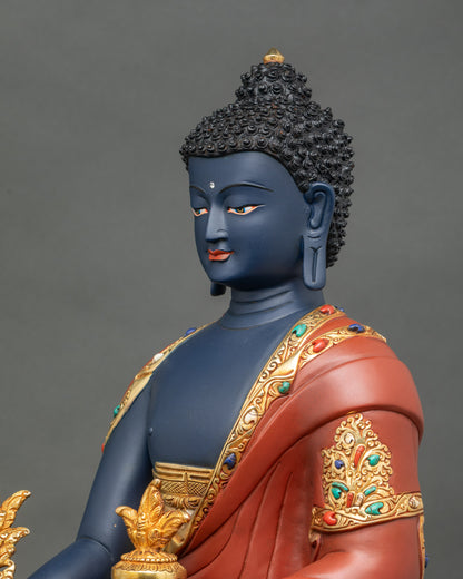 Side detail of Blue Medicine Buddha sculpture, holding myrobalan plant and medicinal bowl