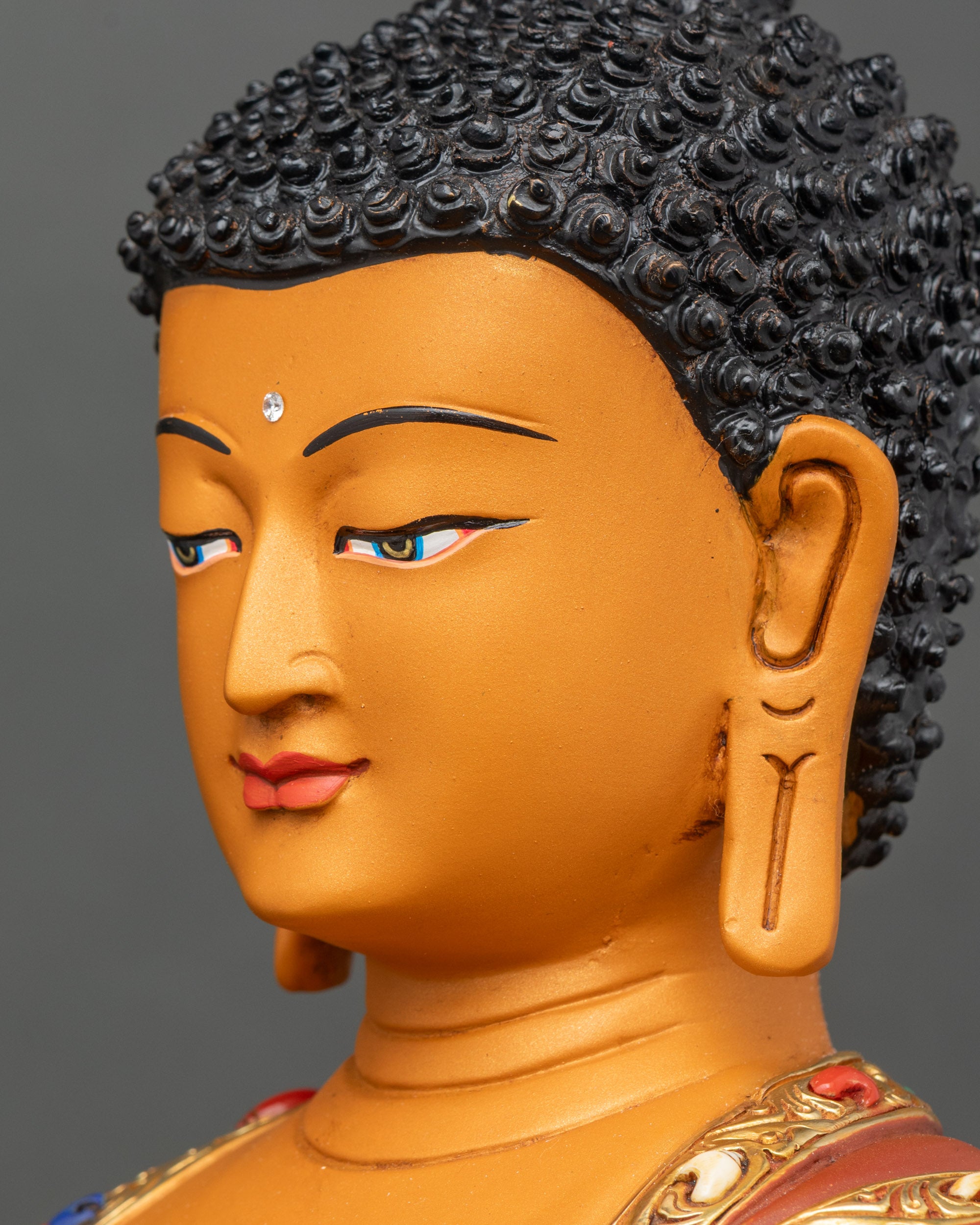 Side face close-up of Shakyamuni Buddha statue showing tranquil expression and lotus pedestal