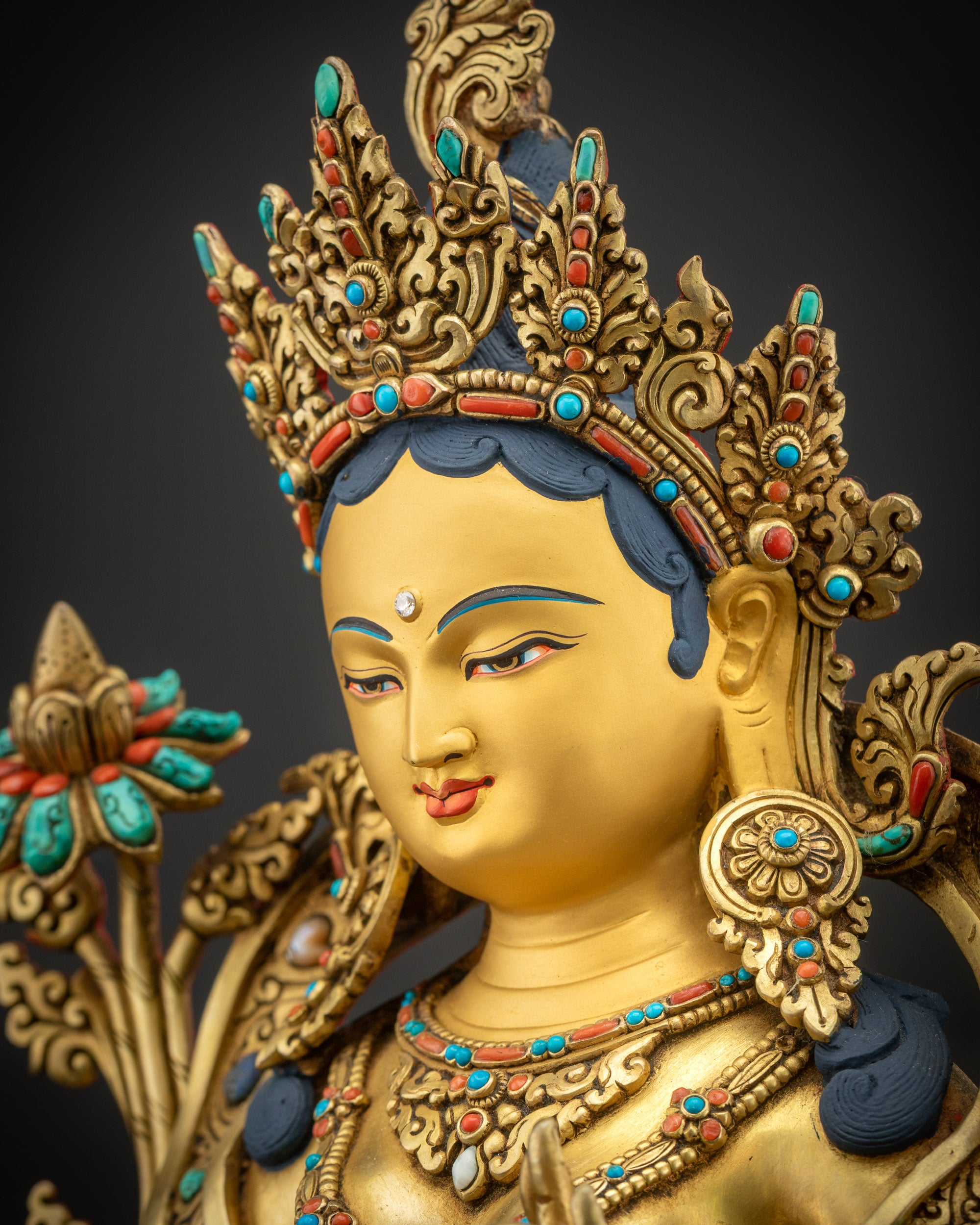 Side face close up Green Tara Statue with jeweled crown, necklaces, and earrings