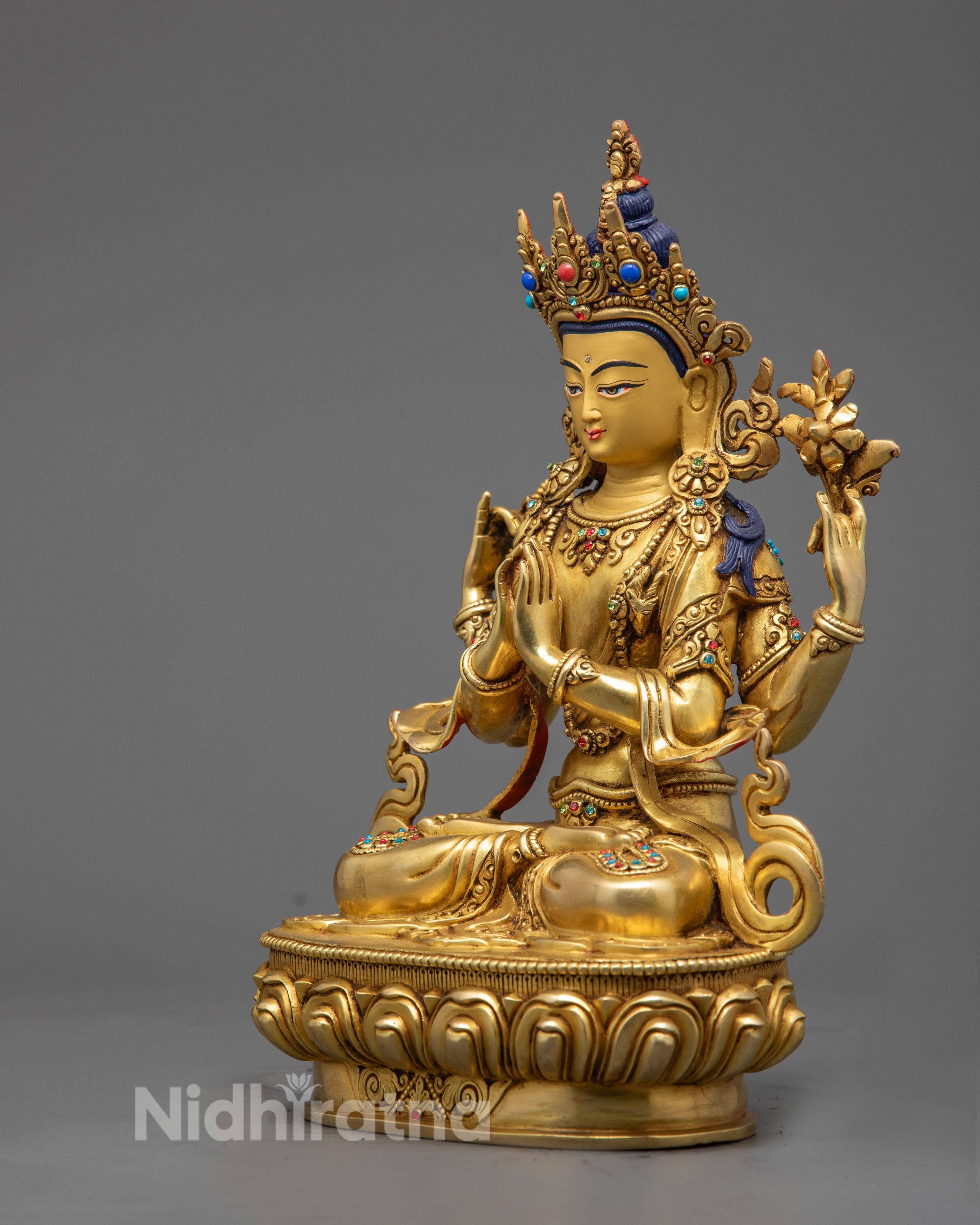 Chenrezig sculpture showing the lotus stem held in one hand and the semi‑precious stone adornments along the garment.