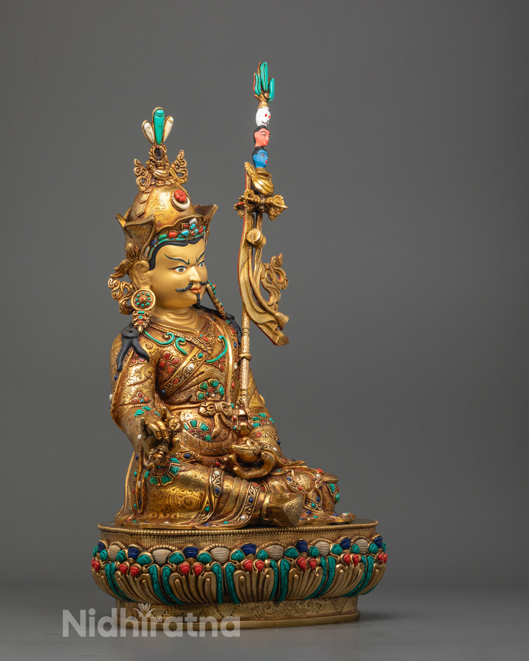 Guru Rinpoche Buddha statue showing detailed robes and lotus base in vibrant acrylic hues