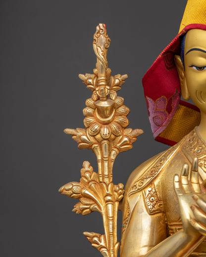 Side profile of Gyaltsab Je holding a scripture in Vitarka Mudra, yellow Pandita hat, and monastic robes.