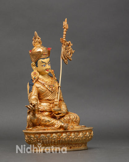 Side profile of Padmasambhava statue, gold fire-gilded finish with khatvanga staff