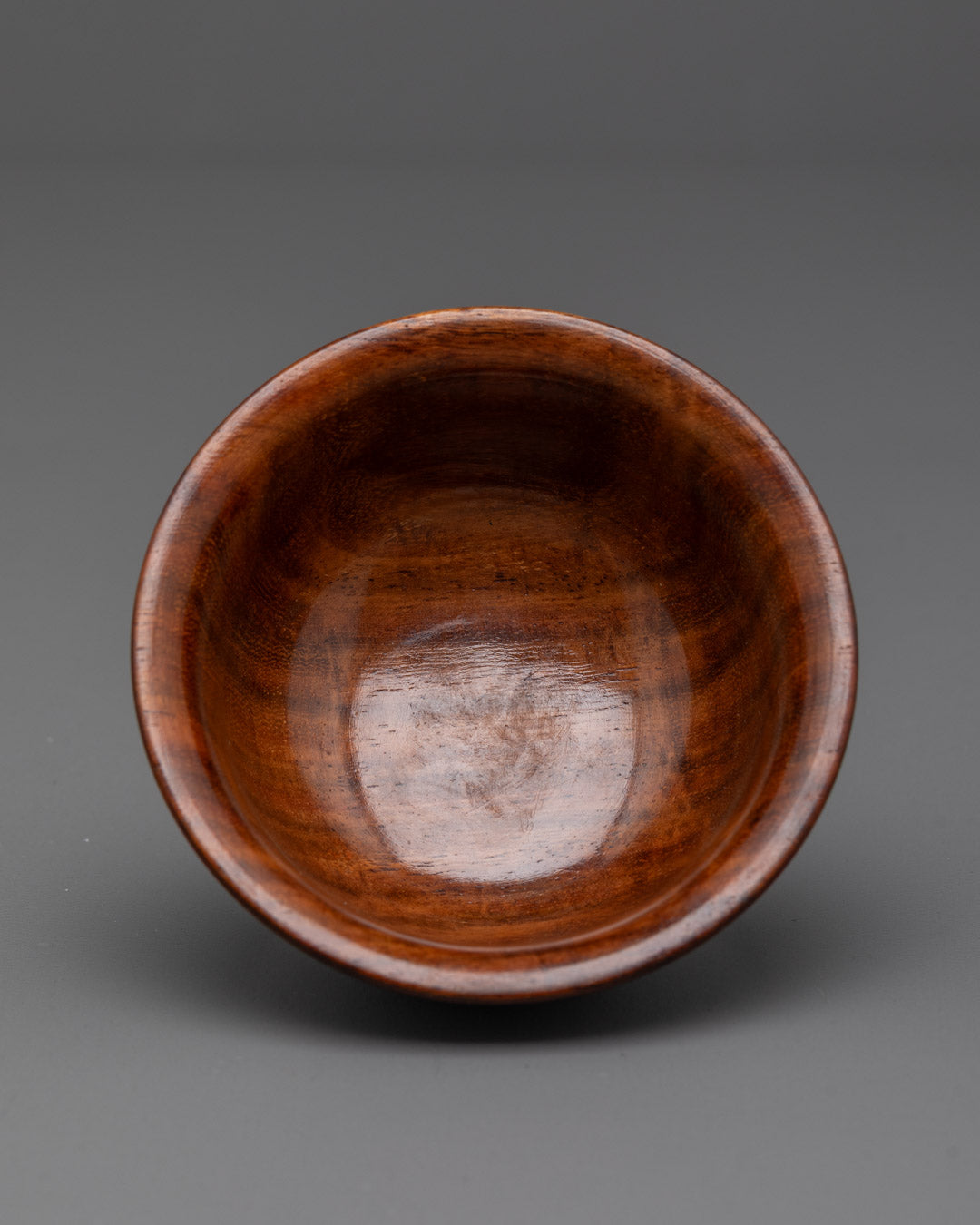 Side profile of Tibetan wooden tea bowl showing elegant shape and rich brown polish
