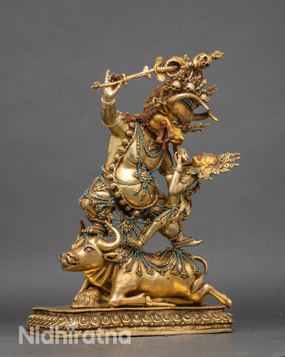 Side profile of Yamantaka statue with gold gilding and lotus base