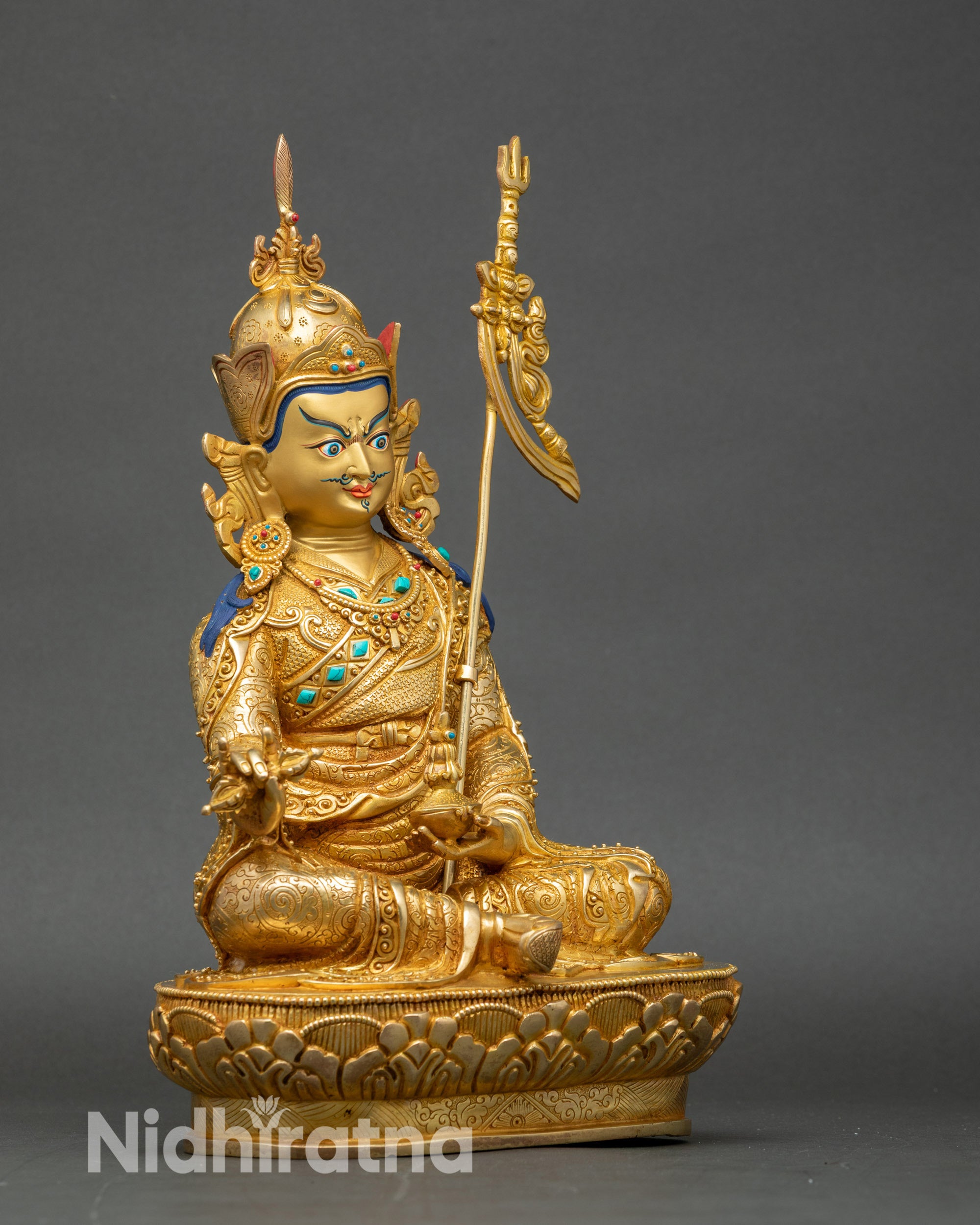 Side profile of authentic Guru Rinpoche Buddhist statue with lotus staff and traditional iconography
