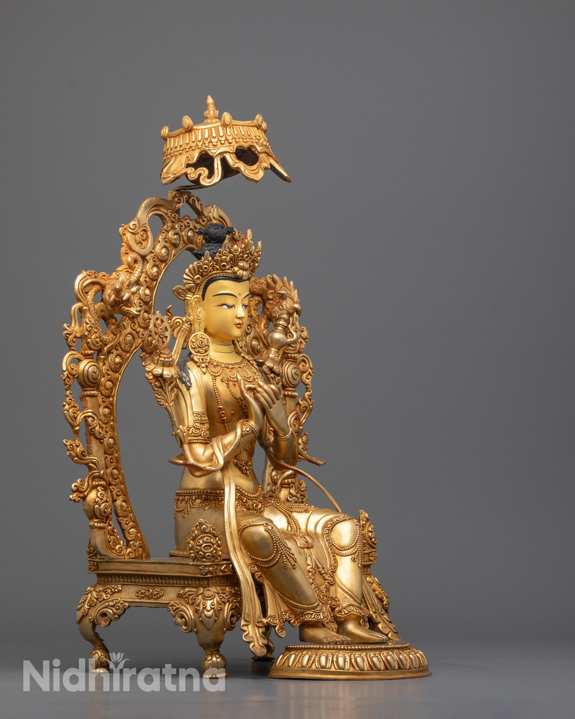 Side profile of traditional Maitreya Buddha sculpture showcasing copper body