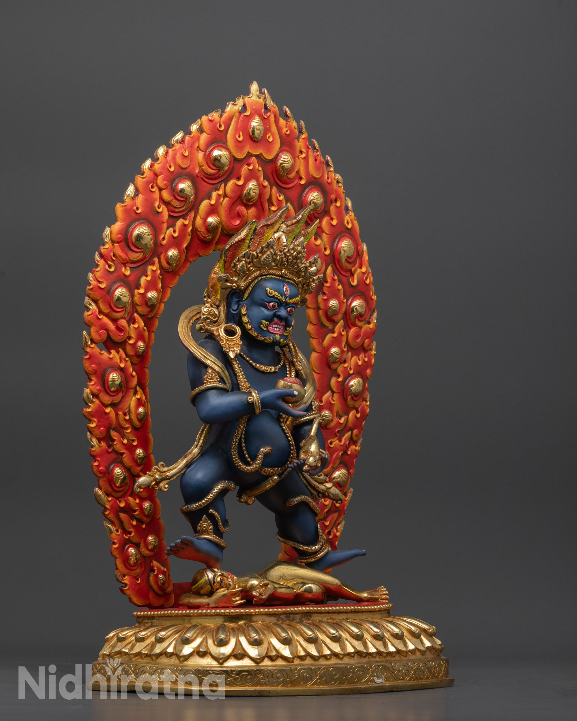 Side view Black Dzambhala figure with fire halo, dynamic stance, and wrathful ornaments