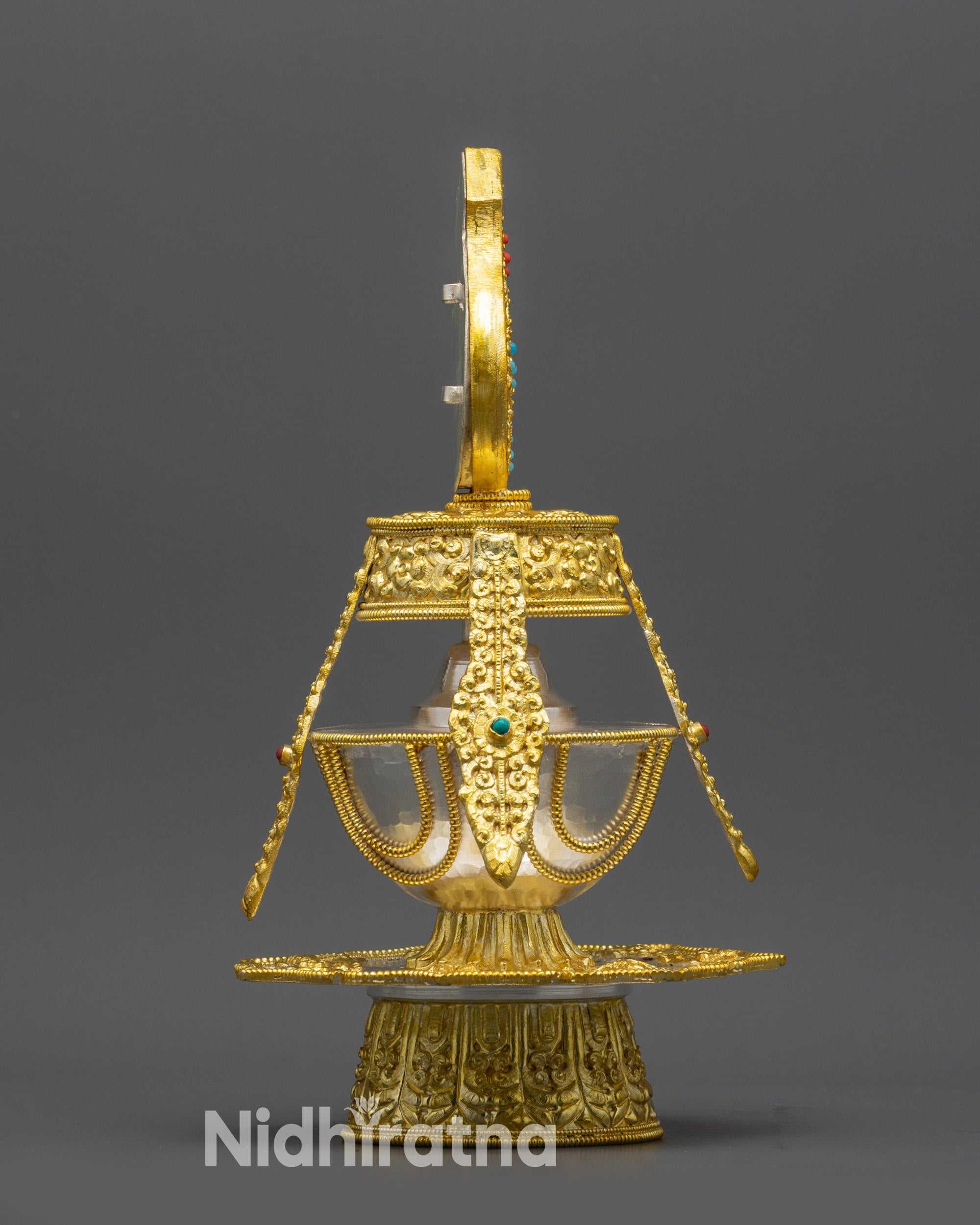 Side view Buddhist Kalasha showing curved silver body with gold-plated base and pedestal