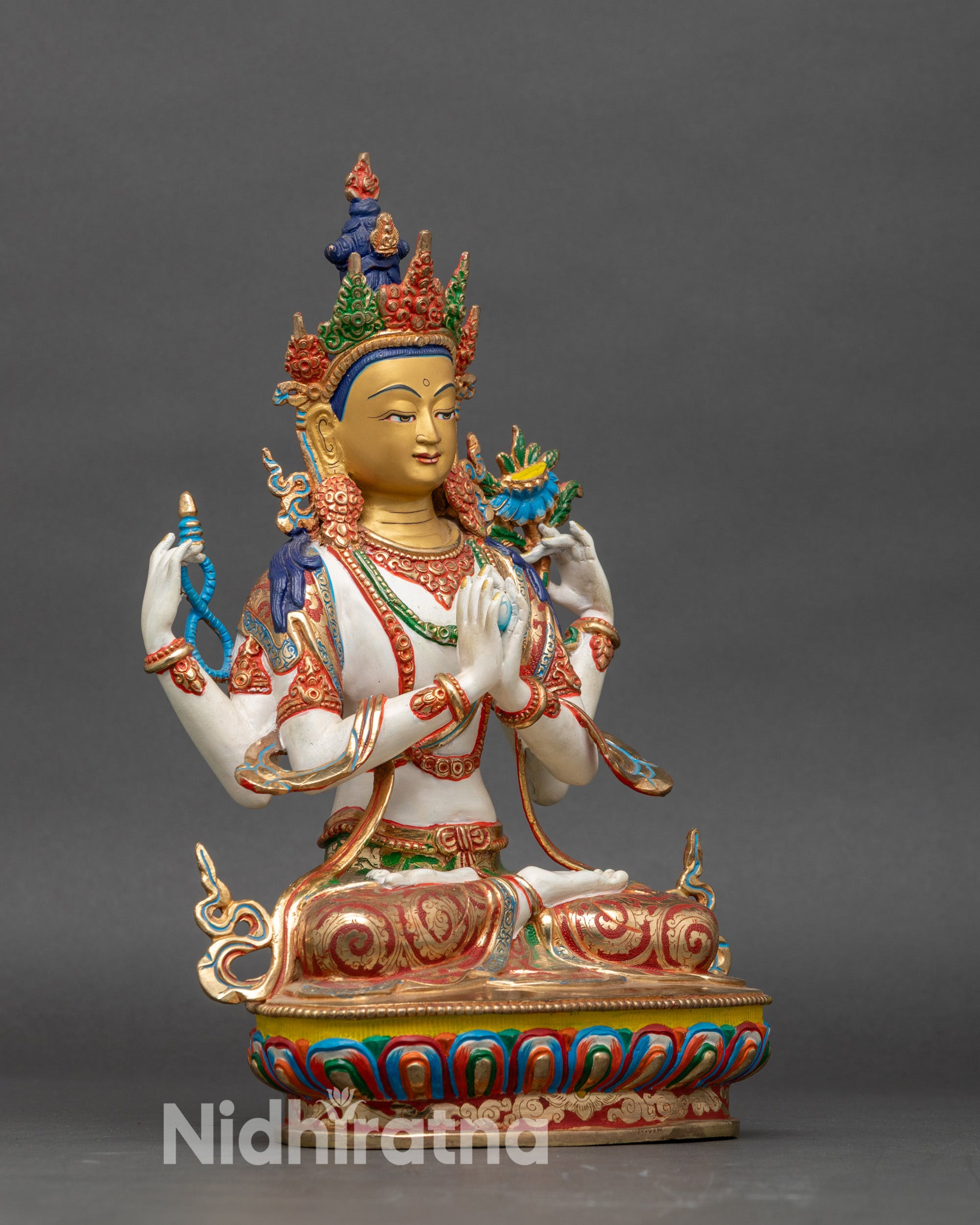 Side view Chenrezig statue with four arms holding crystal rosary, lotus, and wish-fulfilling gem