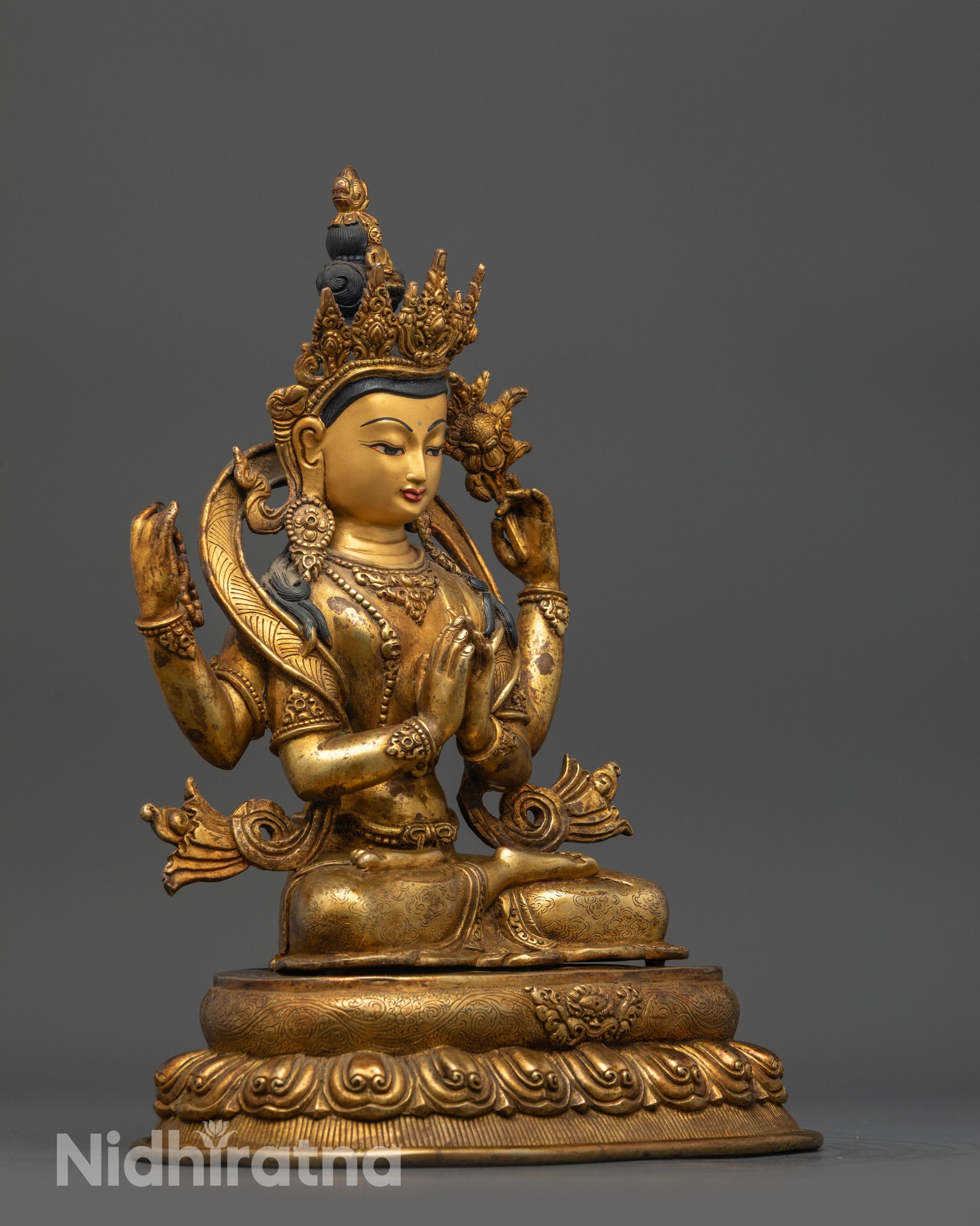 Side view Chenrezig with four arms holding rosary, lotus, and wish-fulfilling gem