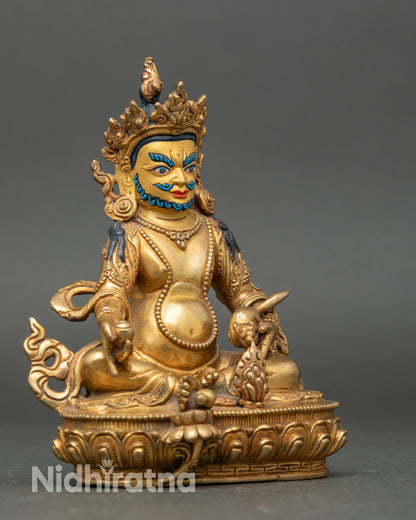Side view Dzambhala statue seated on lotus throne with right leg extended on lotus flower