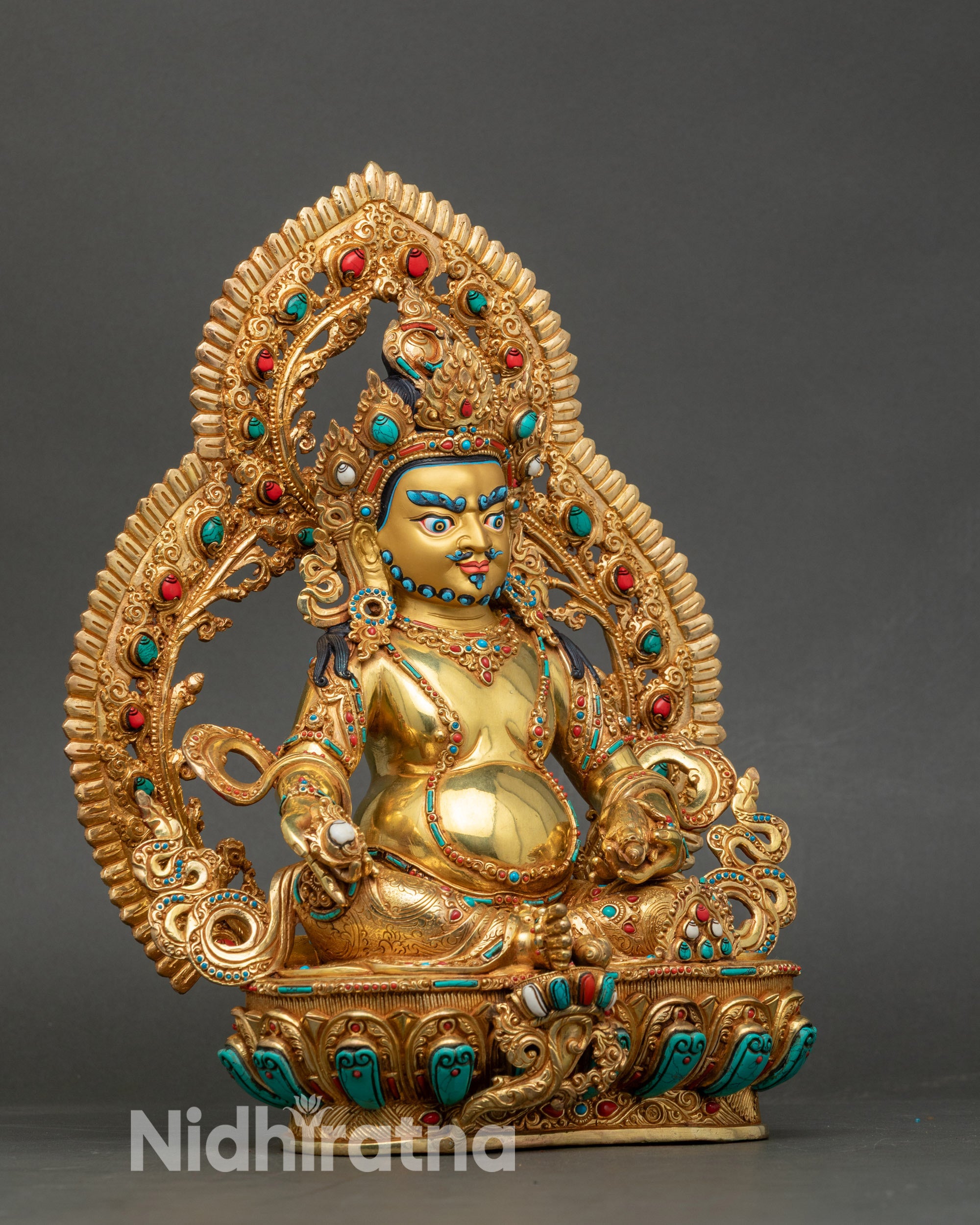 Side view Dzambhala wealth deity statue seated in royal ease with mongoose and lotus seat