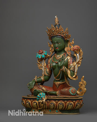 Side view Green Tara Buddha statue in royal ease pose on colored lotus seat
