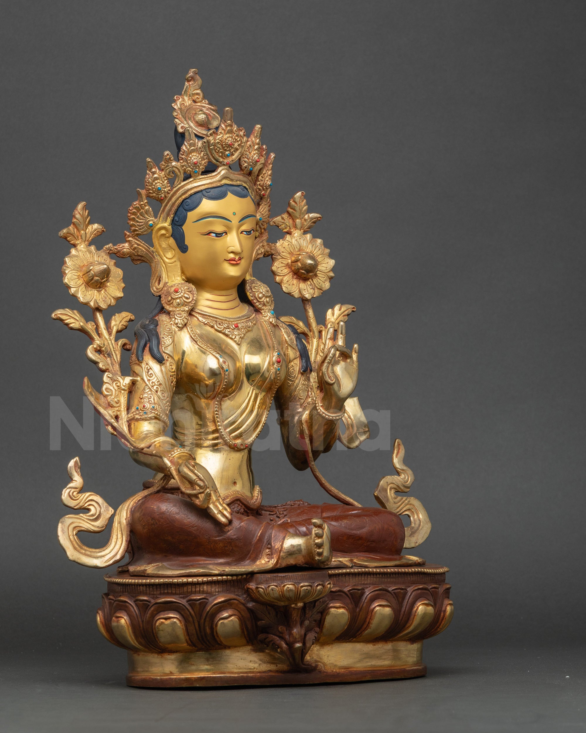 Side view Green Tara sculpture seated on lotus throne with right leg extended