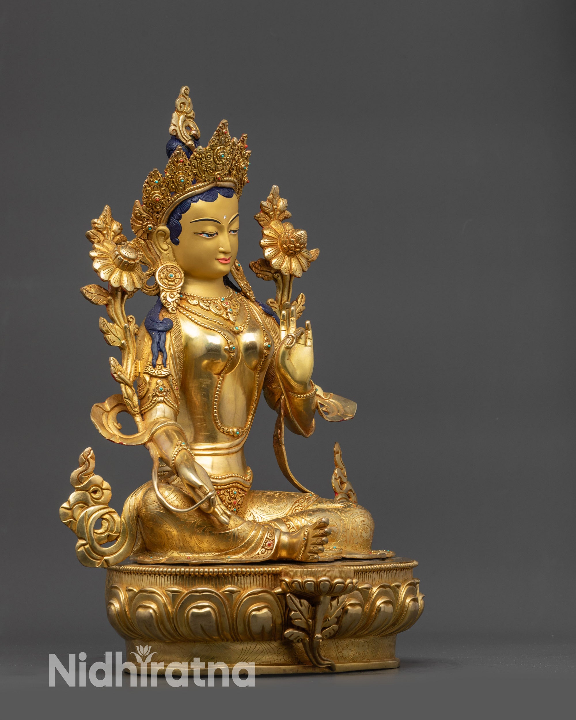 Side view Green Tara seated on lotus with royal ease mudra and halo
