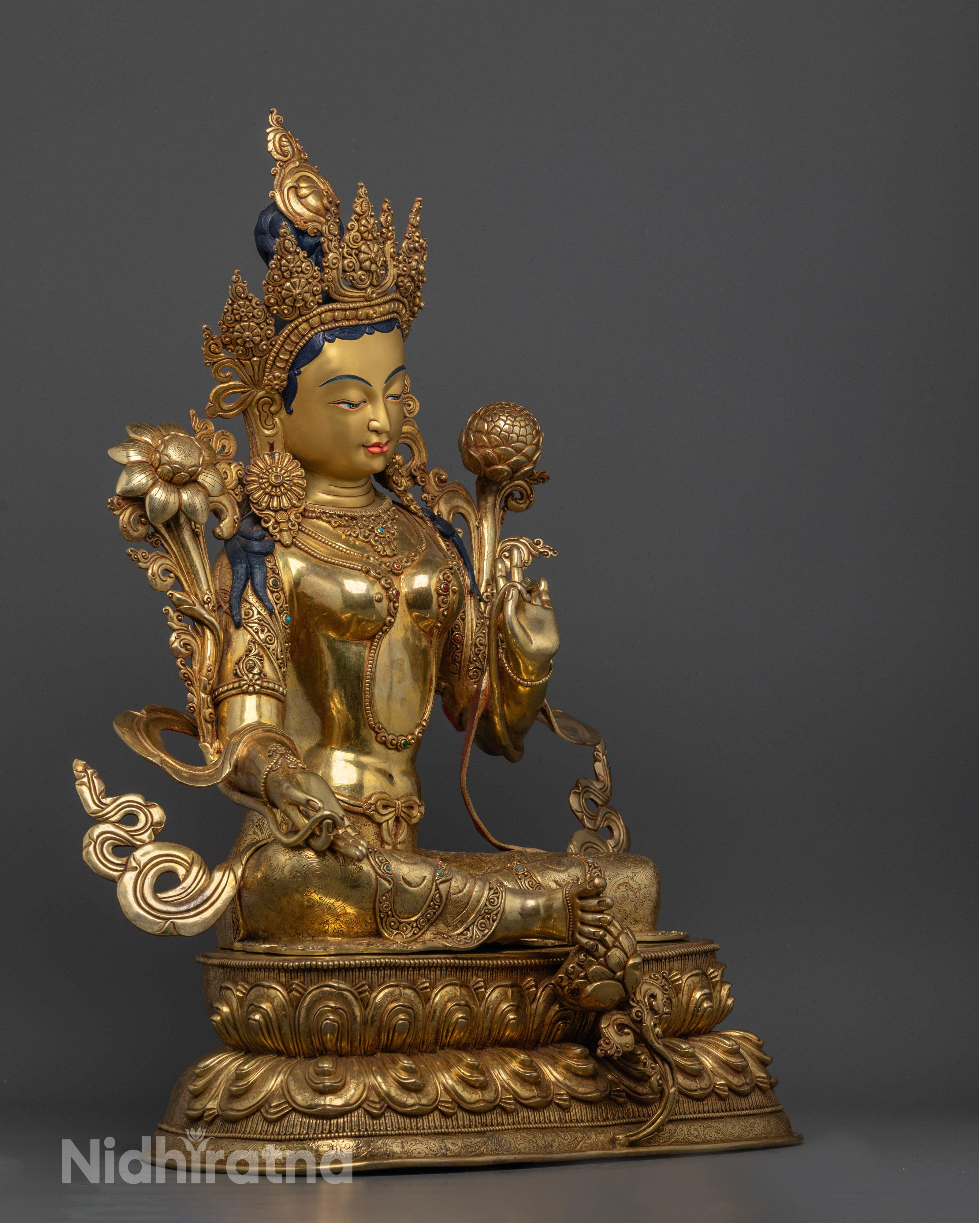 Side view Green Tara statue with right leg extended on lotus flower, Varada and Vitarka mudras, gold gilded copper