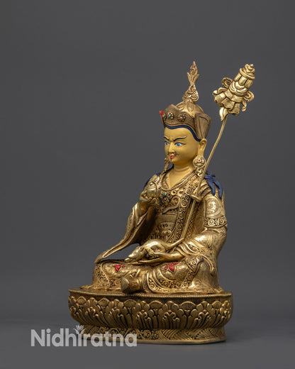 Side view Guru Norlha sculpture holding chintamani, jewel-spitting mongoose, and trident