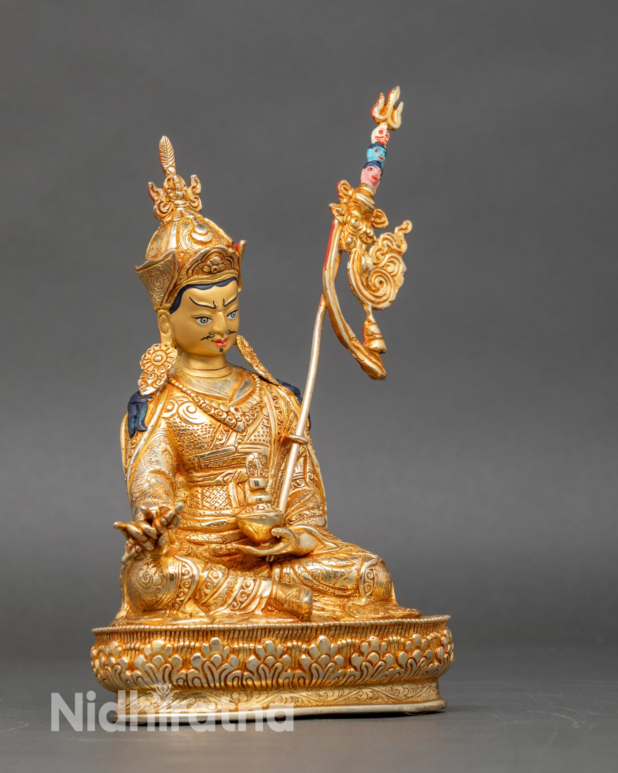 Side view Guru Padmasambhava statue with flowing kasaya robes and iconic lotus hat