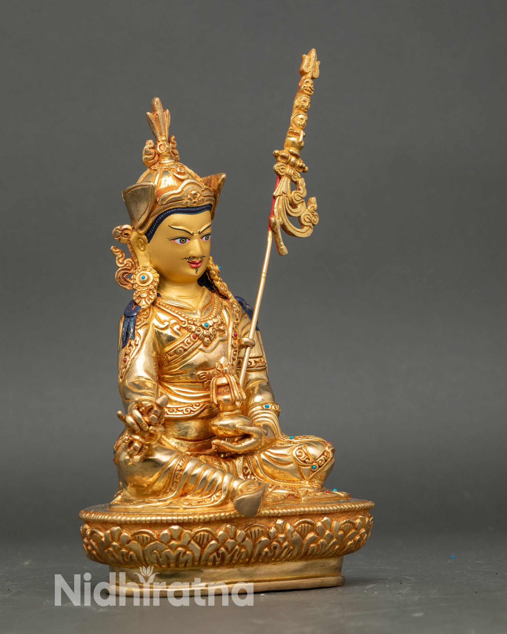 Side view Guru Rinpoche seated on lotus throne with khatvanga on shoulder